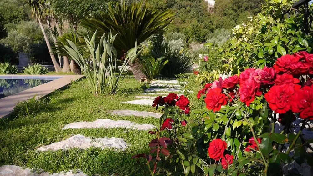 Flower garden with stone pad near swimming pool